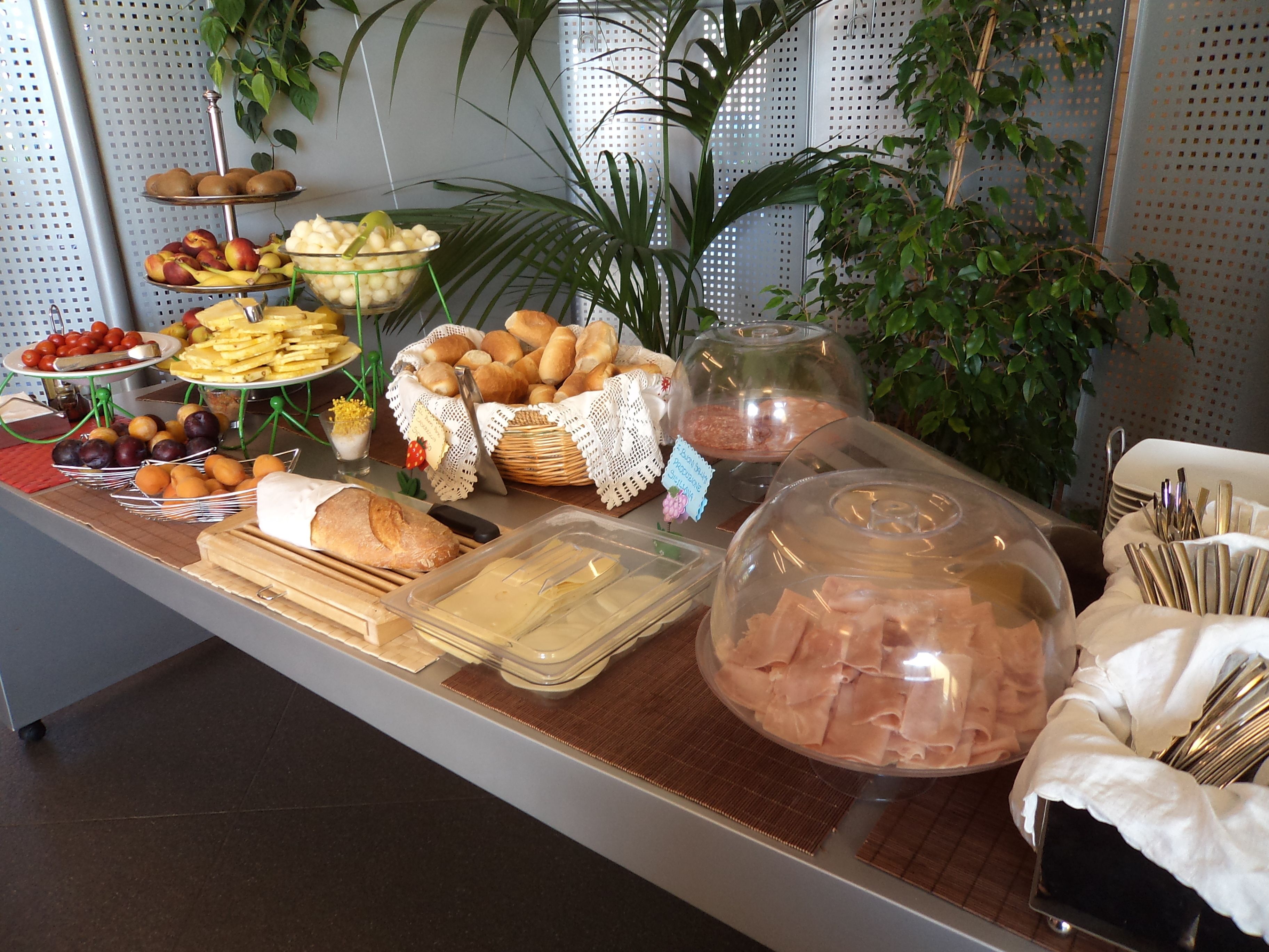 Ein reichhaltiges Buffet mit verschiedenen Speisen, darunter Obst, Brot und Fleisch.