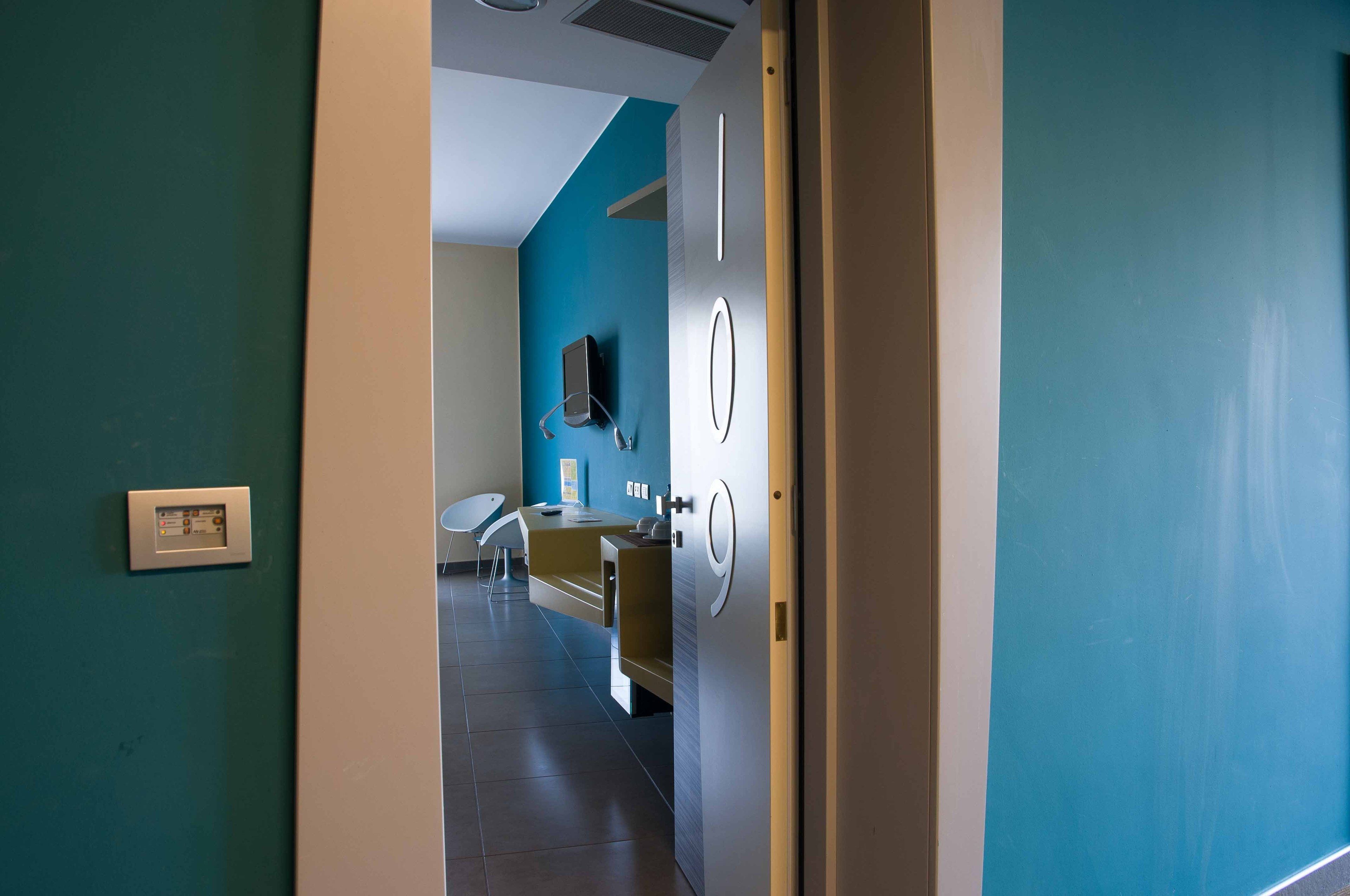 A modern bathroom with a blue wall, a sink, and a toilet.