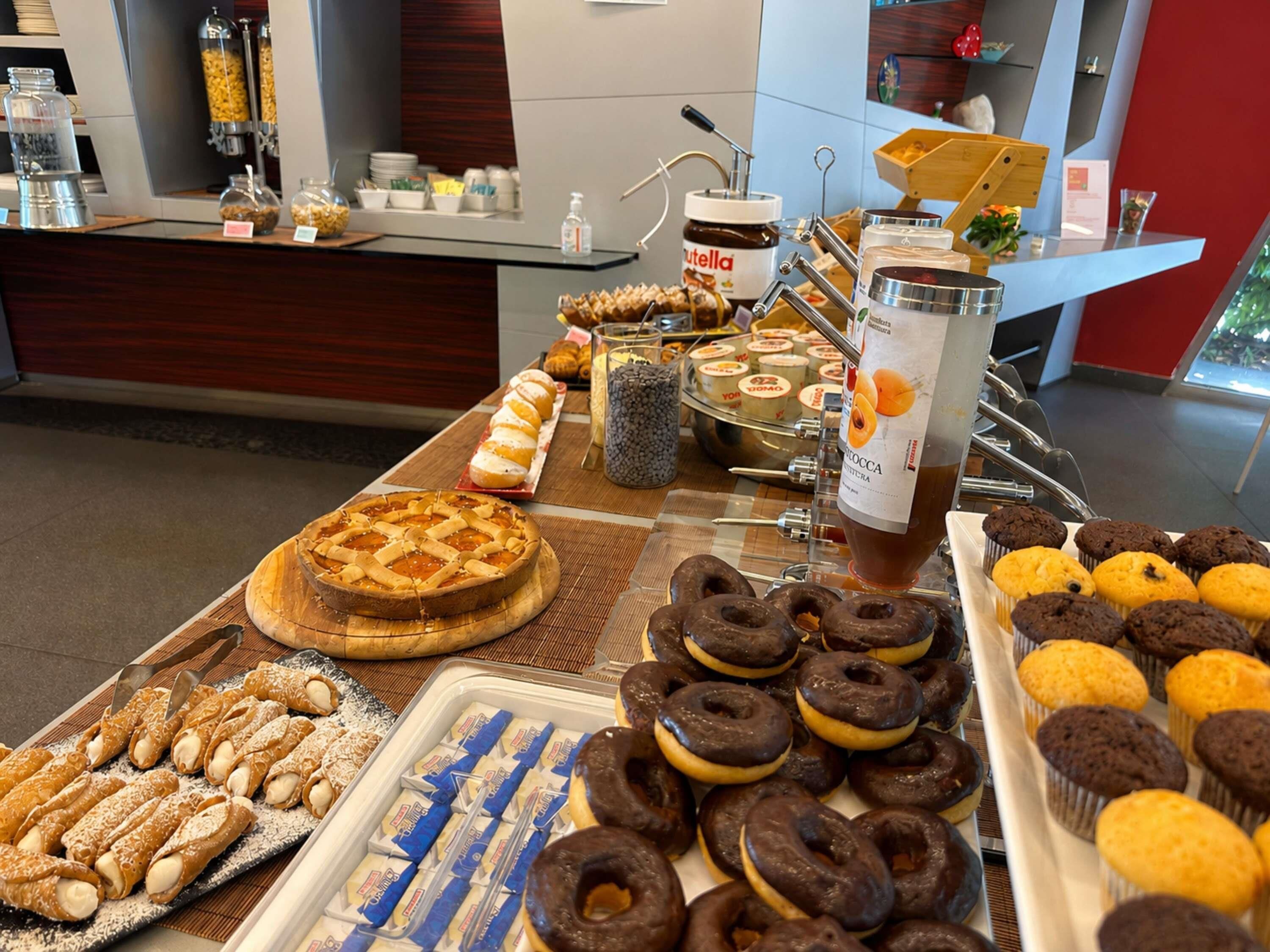 Un bufé con diversas opciones de panadería, incluyendo tartas, rosquillas y pasteles.