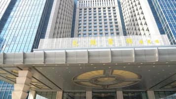 A hotel with a modern facade, large windows, and a prominent entrance with a circular design.