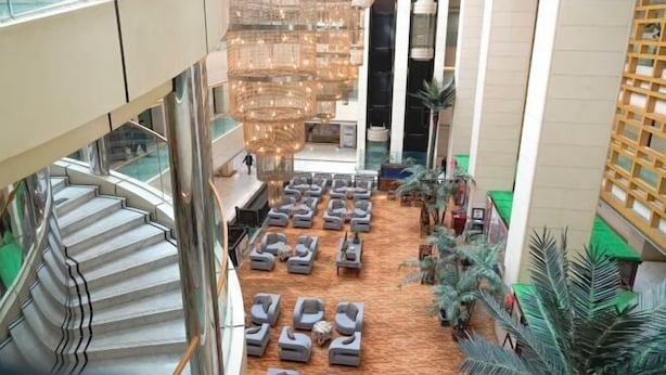 A hotel lobby with a central seating area, a staircase, and a modern chandelier. - Baotou Hotel State Guest Building (Baotou)