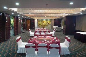 A banquet hall with round tables, white chairs, and a chandelier. - Baotou Hotel State Guest Building (Baotou)