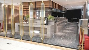A modern hotel lobby with a reception desk, a seating area, and a kitchen in the background. - Baotou Hotel State Guest Building (Baotou)