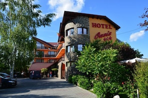 A hotel with a stone facade, multiple windows, and a sign that reads 'HOTEL Oasis.' - Hotel Oasis (Brasov)