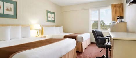 A hotel room with two beds, a desk, a chair, a TV, and a window.
