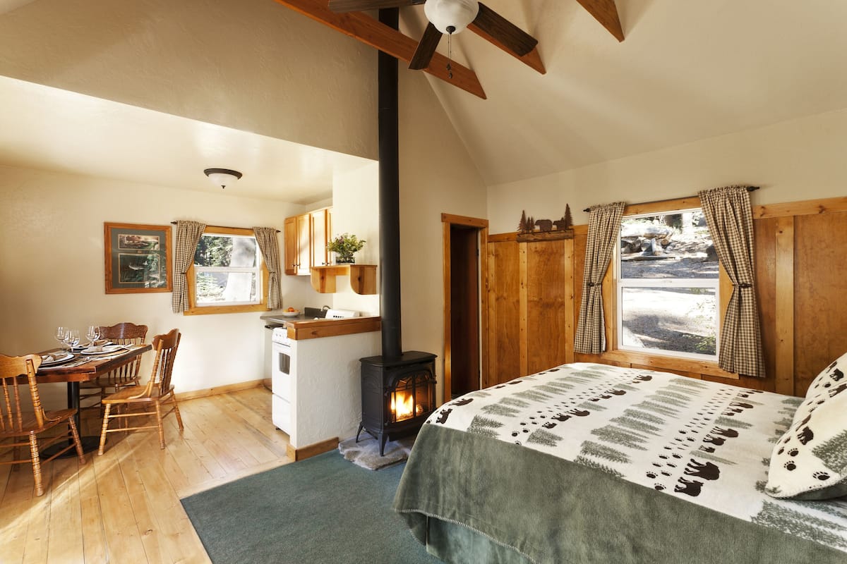 Ein gemütliches Zimmer mit einem Bett, einem Holztisch und einem Kamin.