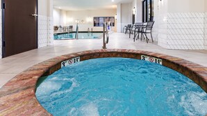 A hot tub with a 3 ft depth marker, a pool in the background, and a dining area with chairs and tables. - Holiday Inn Hotel & Suites Tulsa South by IHG (Tulsa)