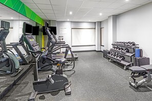 A fitness center with treadmills, elliptical machines, and a rack of dumbbells.