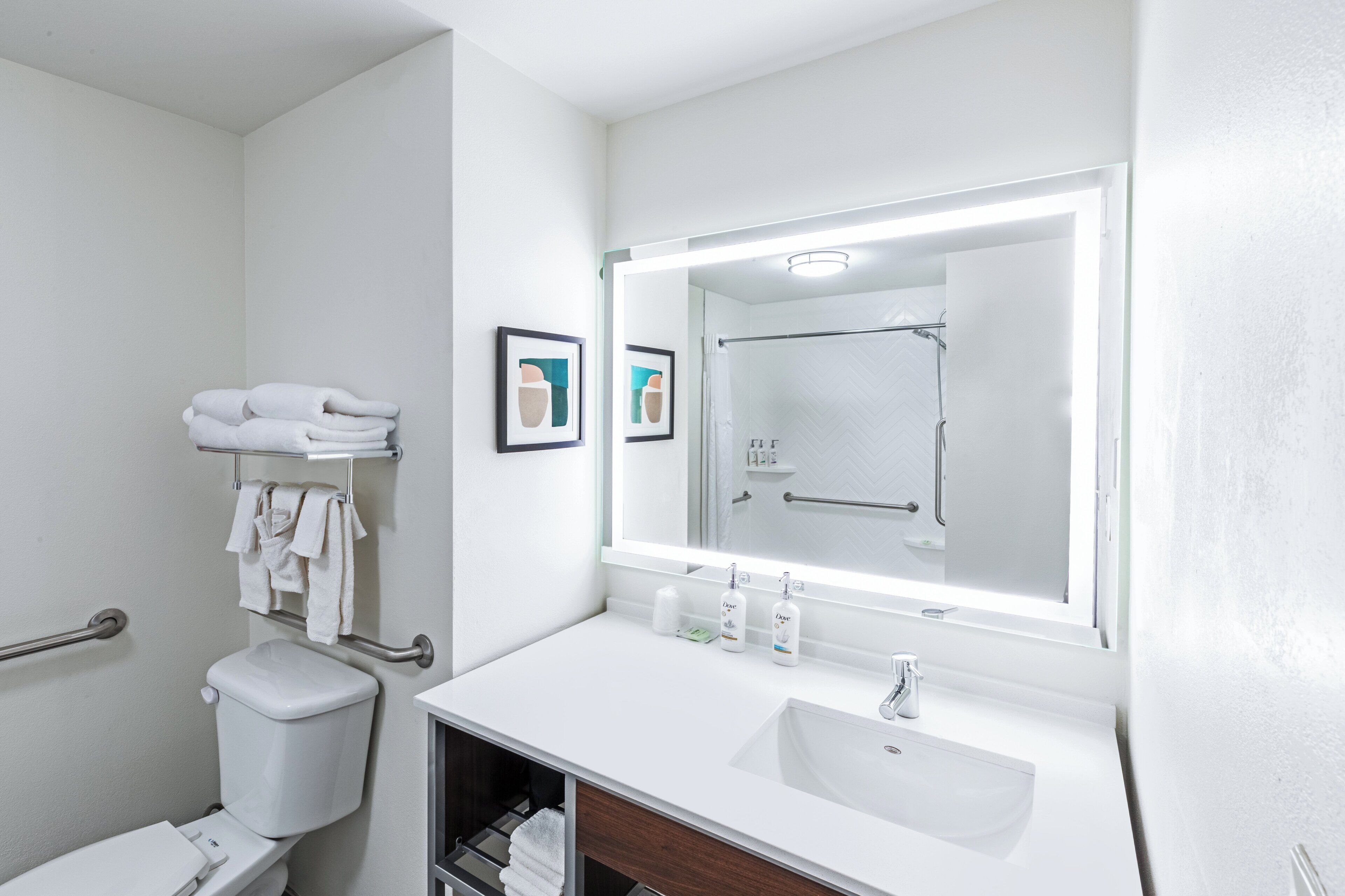 Un baño moderno con un lavamanos blanco, un inodoro y una zona de ducha.