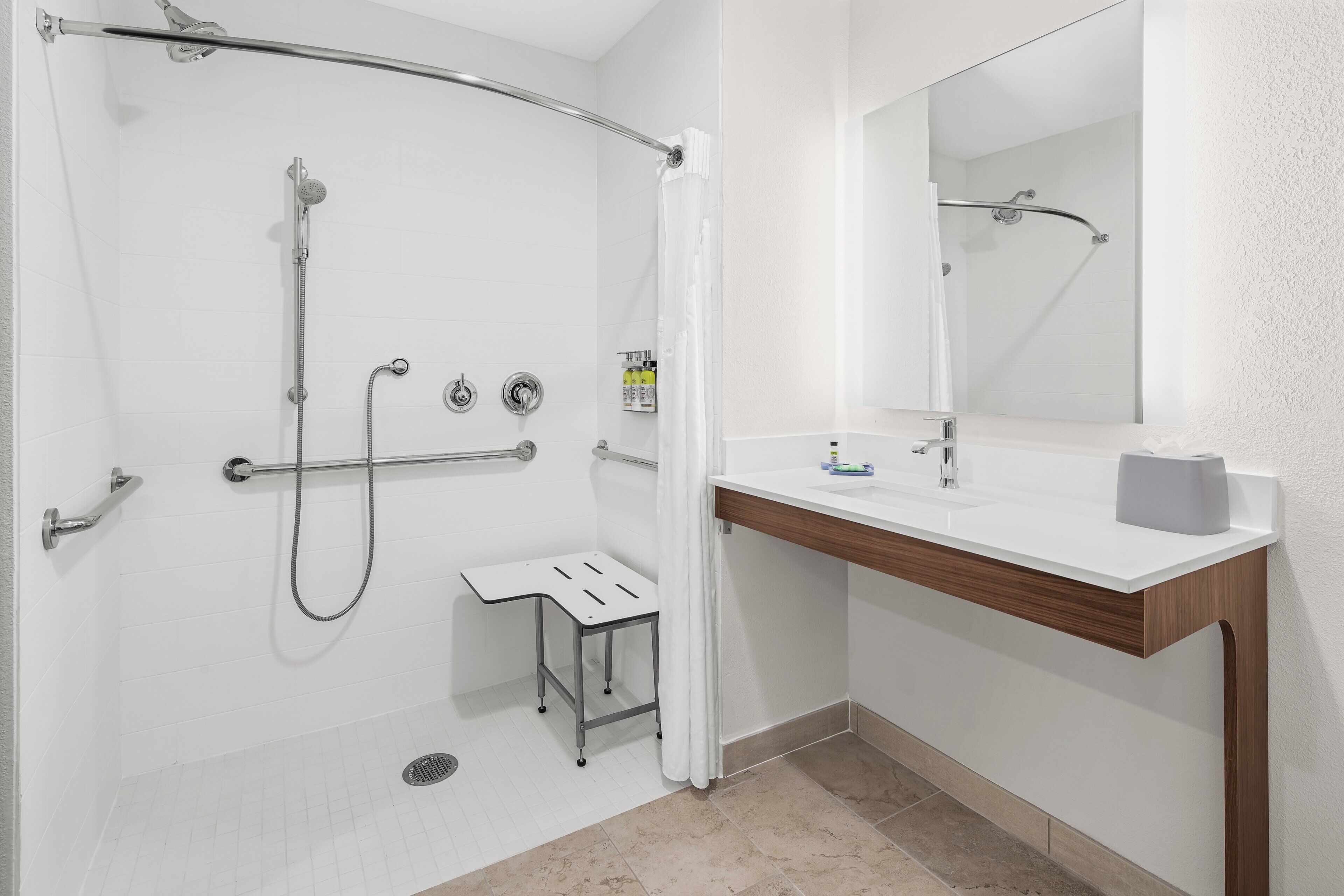 A modern bathroom with a shower, toilet, and sink.