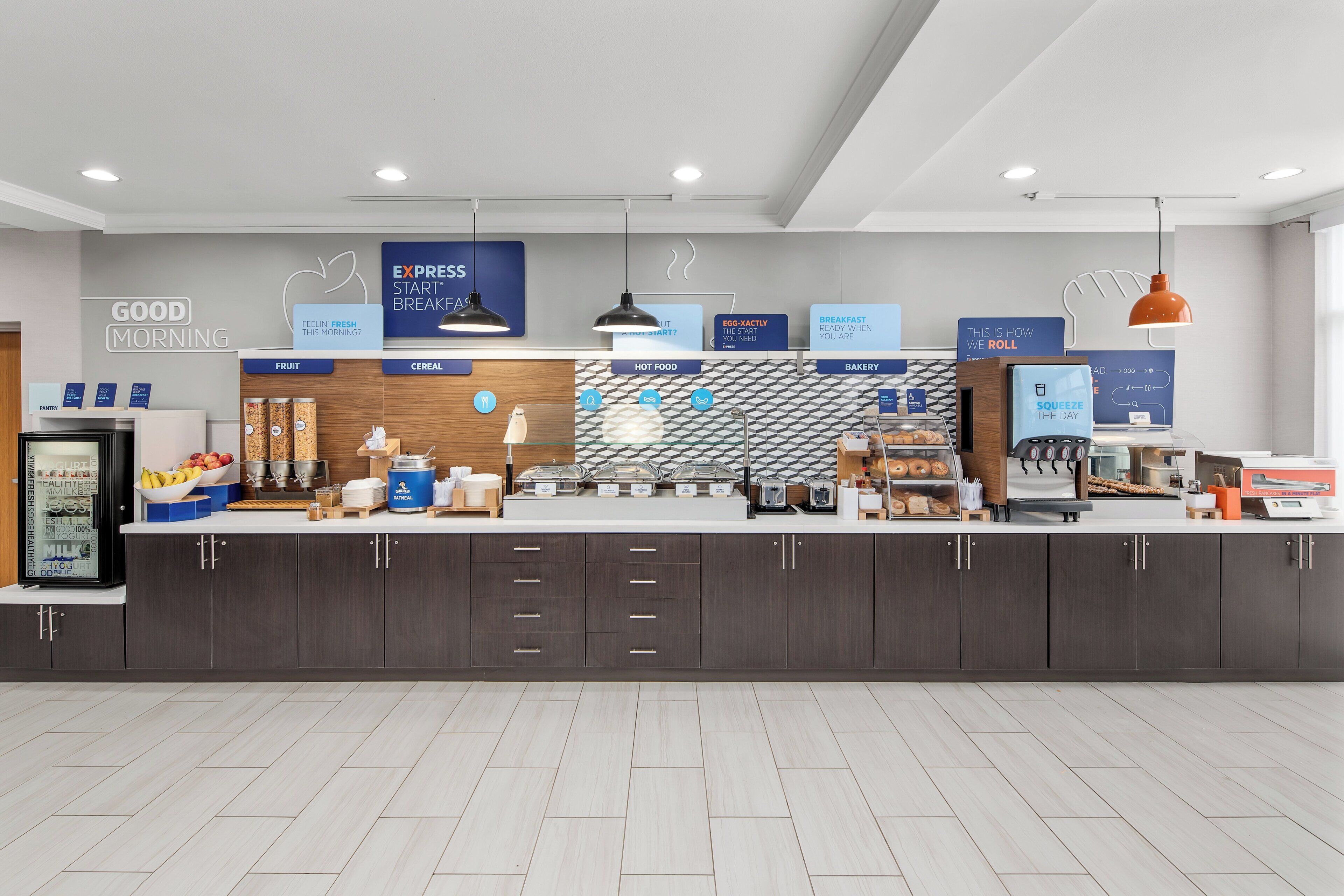 A breakfast area with labeled sections for fruit, cereal, hot food, and bakery.
