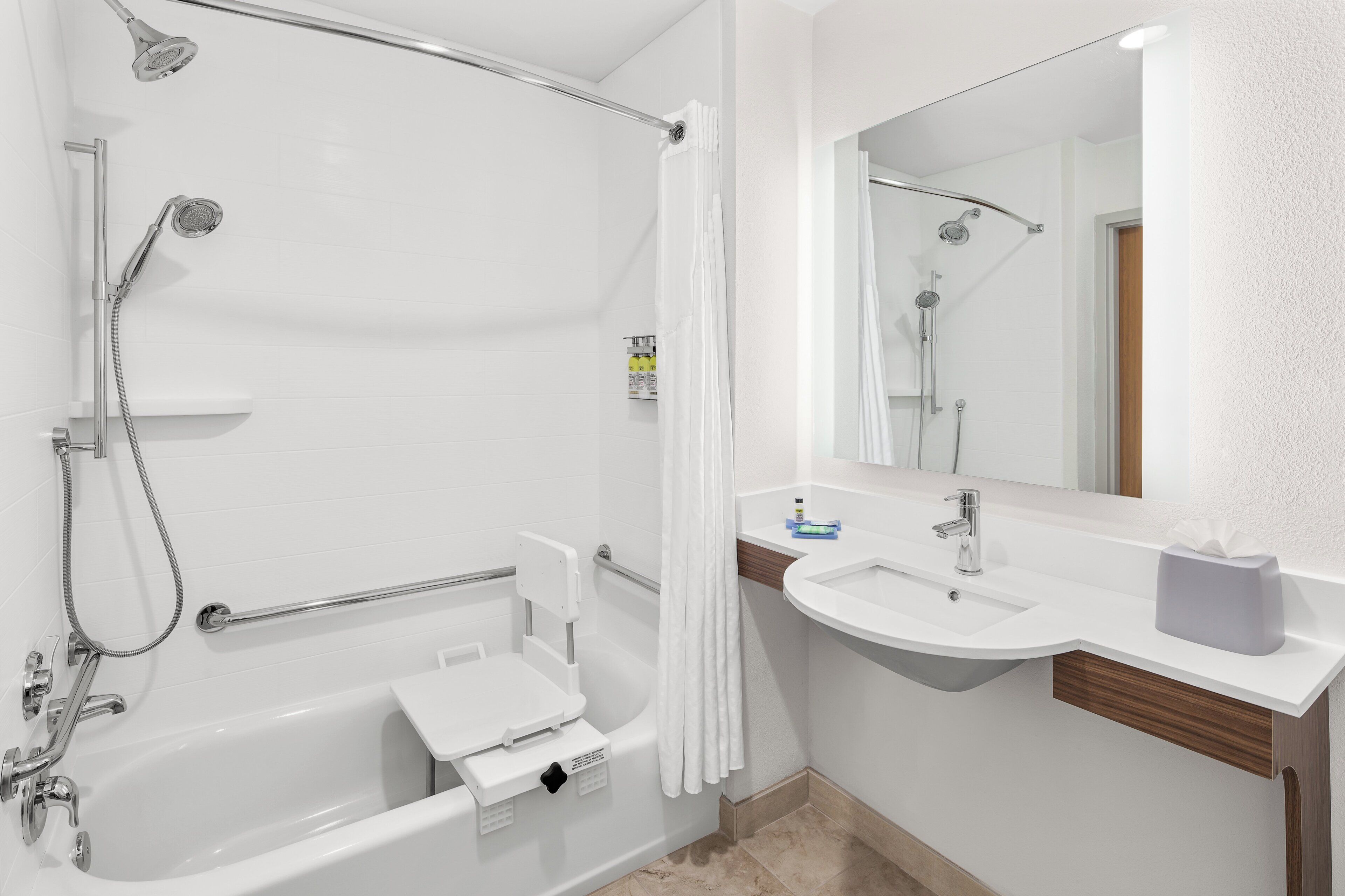 Een moderne badkamer met een bad, douche en wastafel.