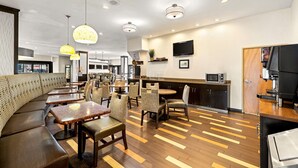 Un restaurant moderne doté d’un long comptoir, de plusieurs espaces de restauration et d’un bar avec une machine à café.