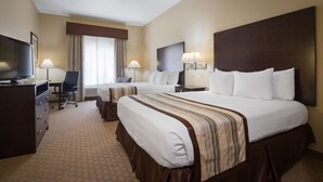 A hotel room with two beds, a desk, a chair, a TV, and a lamp. - Best Western Oasis Inn (Canadian)