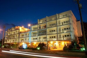 A multi-story hotel with balconies, a ground-level entrance, and a signboard. - Biscayne Suites (Ocean City)