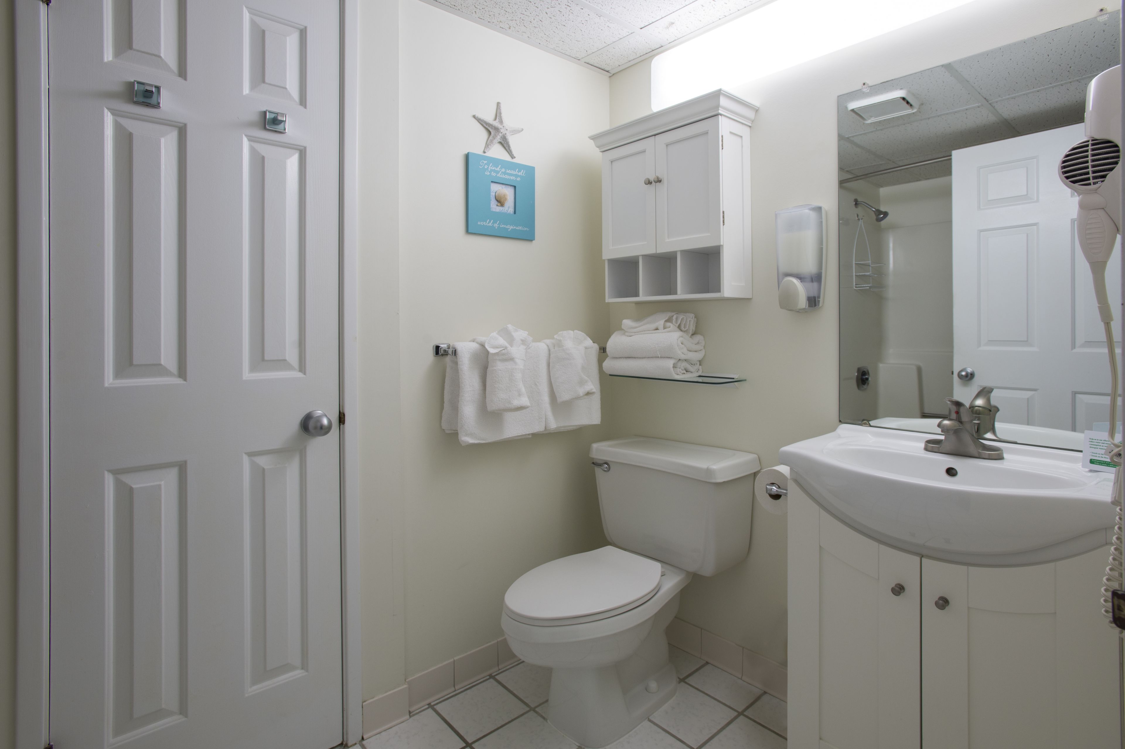 Une salle de bain équipée de toilettes, d’un lavabo et d’un porte-serviettes.
