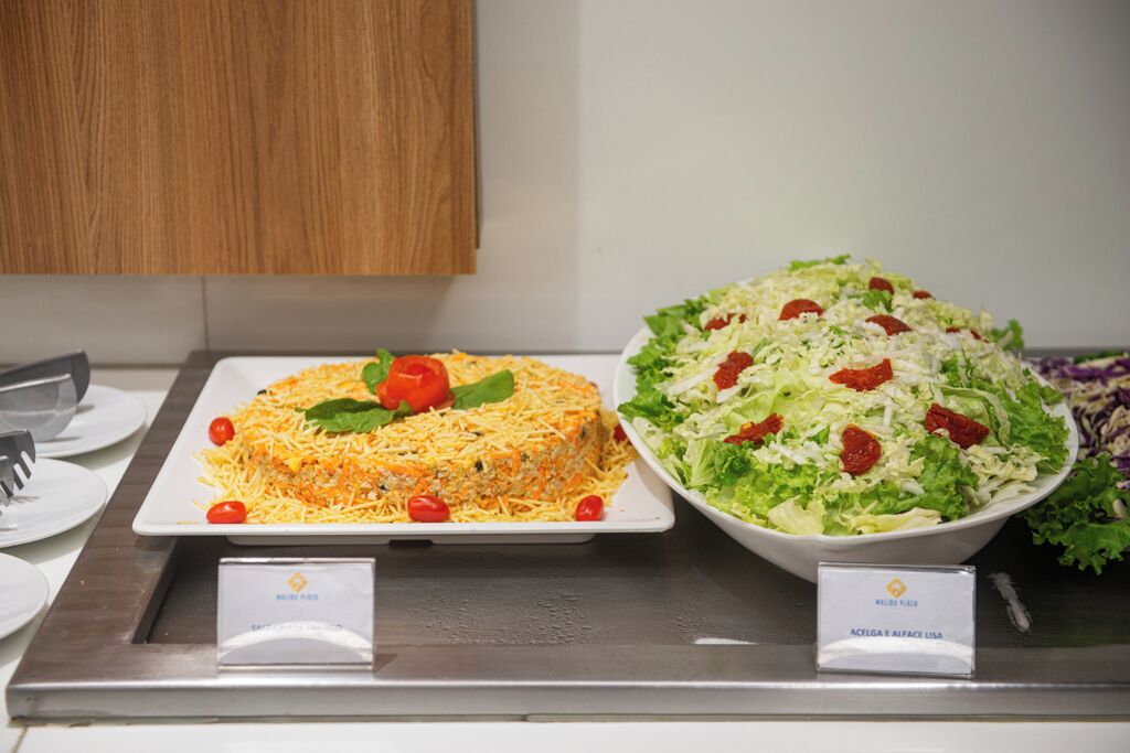 A buffet counter with a salad and a casserole dish.