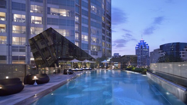 A rooftop pool with lounge chairs and umbrellas, surrounded by high-rise buildings. - Grand Hyatt Shenzhen (Shenzhen)