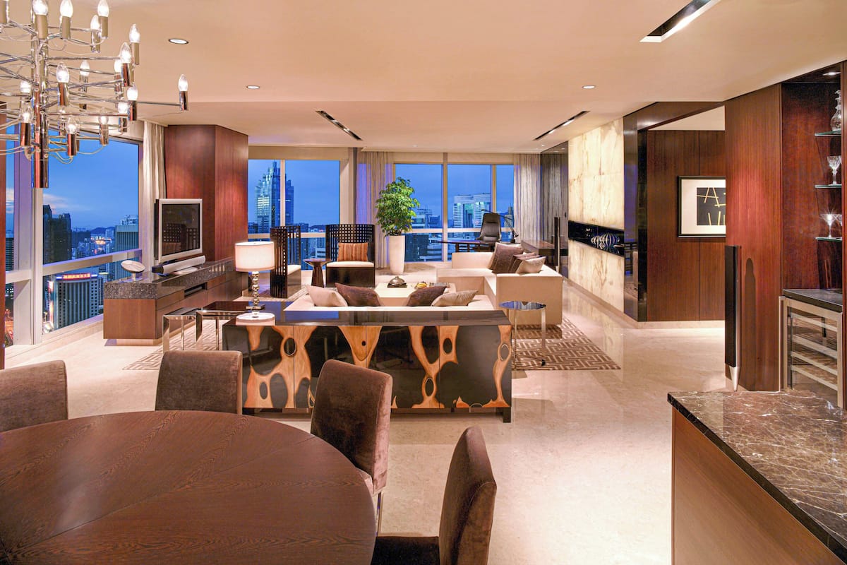 A modern living room with a city view, a dining area, and a kitchen.