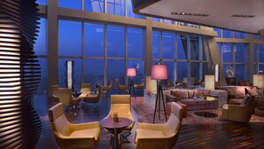 A spacious lobby with modern furniture, large windows, and a high ceiling. - Grand Hyatt Shenzhen (Shenzhen)