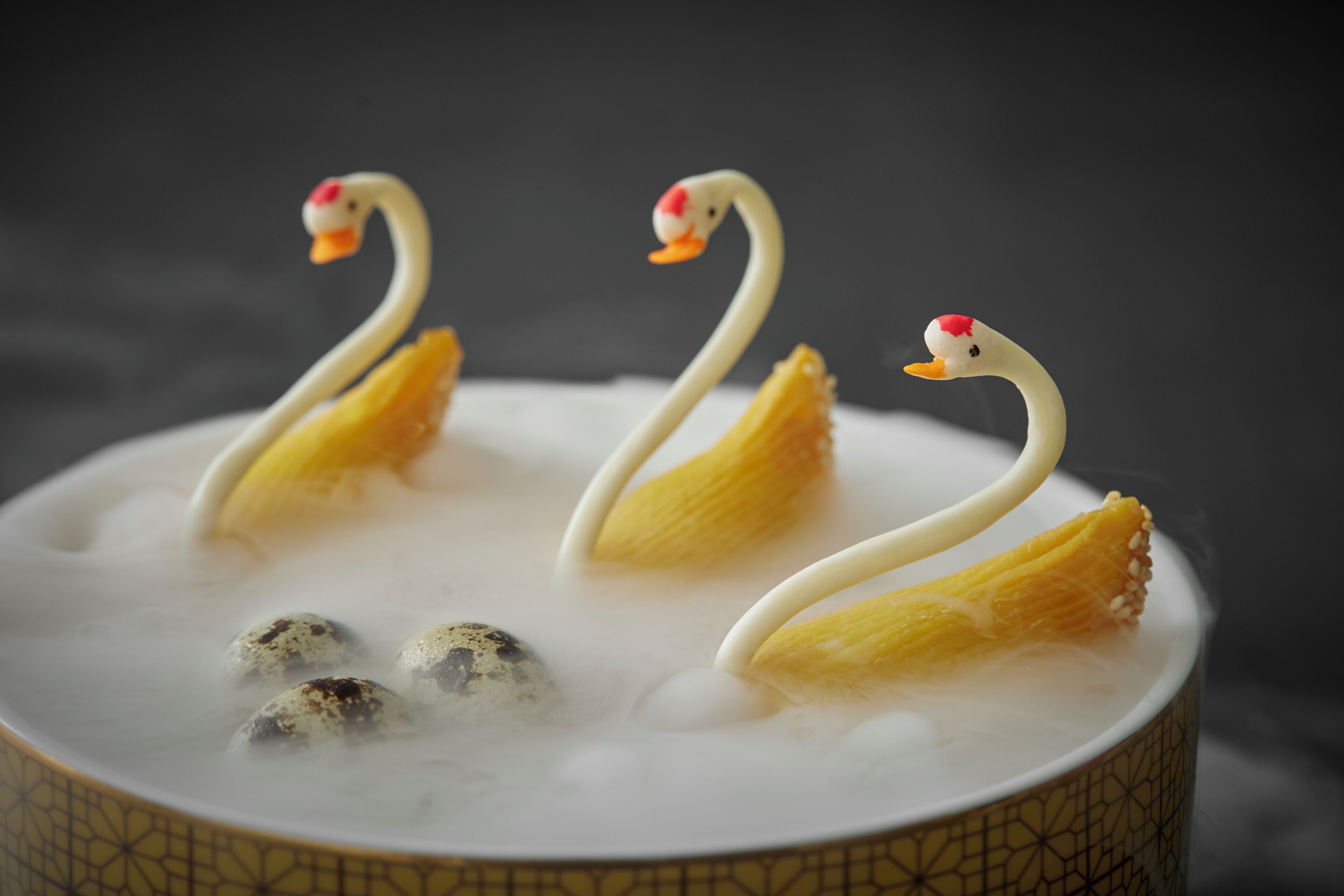 A dessert with swan-shaped decorations and eggs in a patterned bowl.
