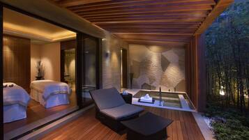 Relax in a serene garden setting with a spa area and comfortable lounge seating.