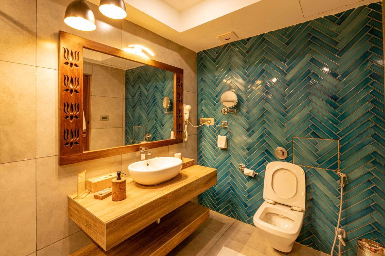 A modern bathroom with a herringbone tile backsplash, a wooden vanity, a large mirror, a toilet, and a shower area.