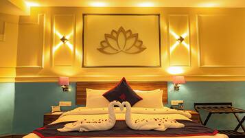 Habitación de hotel con una cama, una decoración de flor de loto montada en la pared y dos apliques.