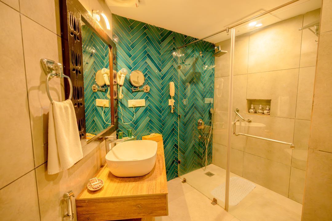 Een moderne badkamer met een grote spiegel, een houten wastafelmeubel, een witte wasbak en een douche met een glazen deur.
