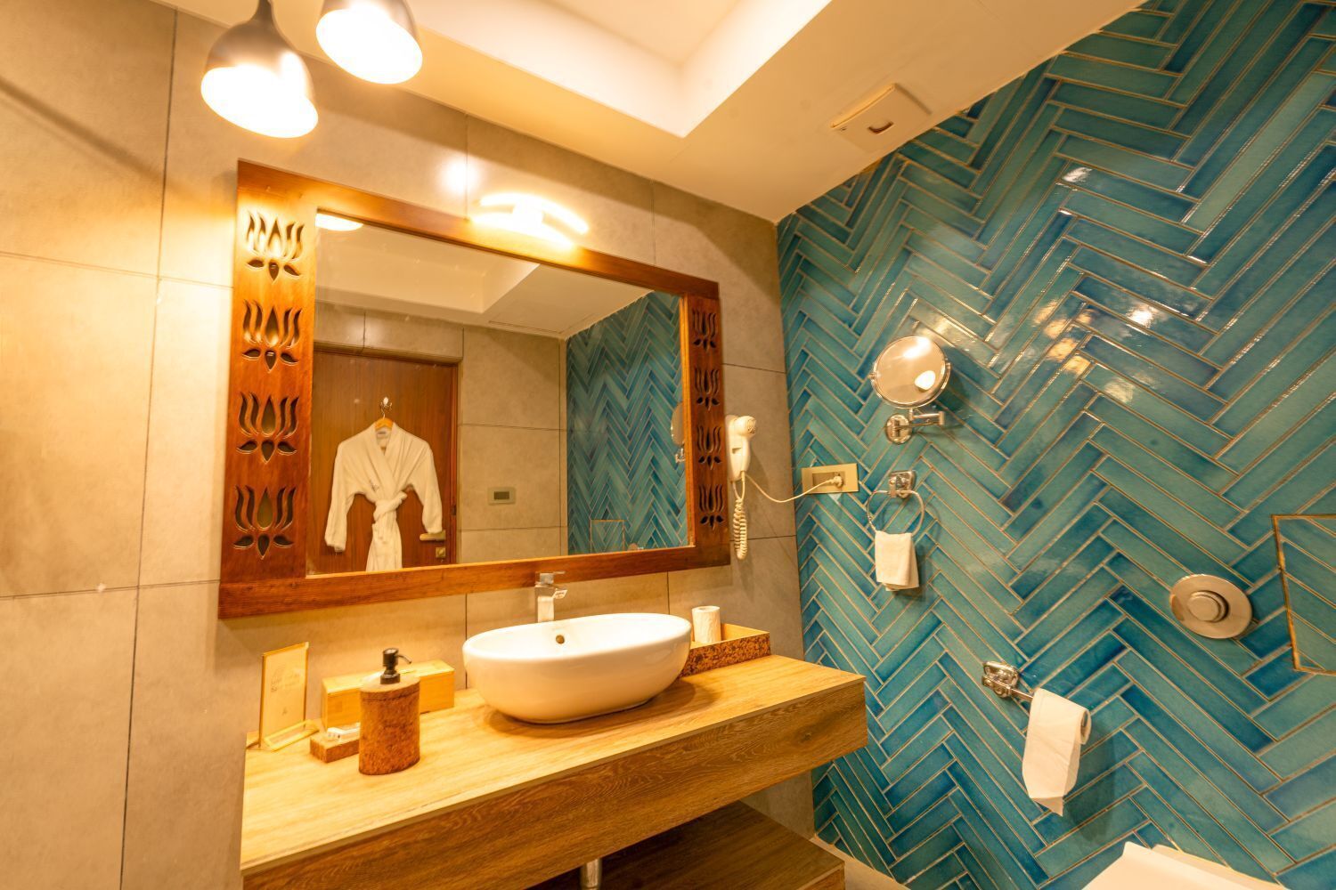 Un baño moderno con un espejo grande, un tocador de madera, un lavabo blanco y una pared con estampado azul de espiga.