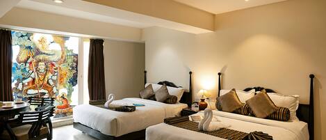 A hotel room with two beds, a dining table, and a mural on the wall.