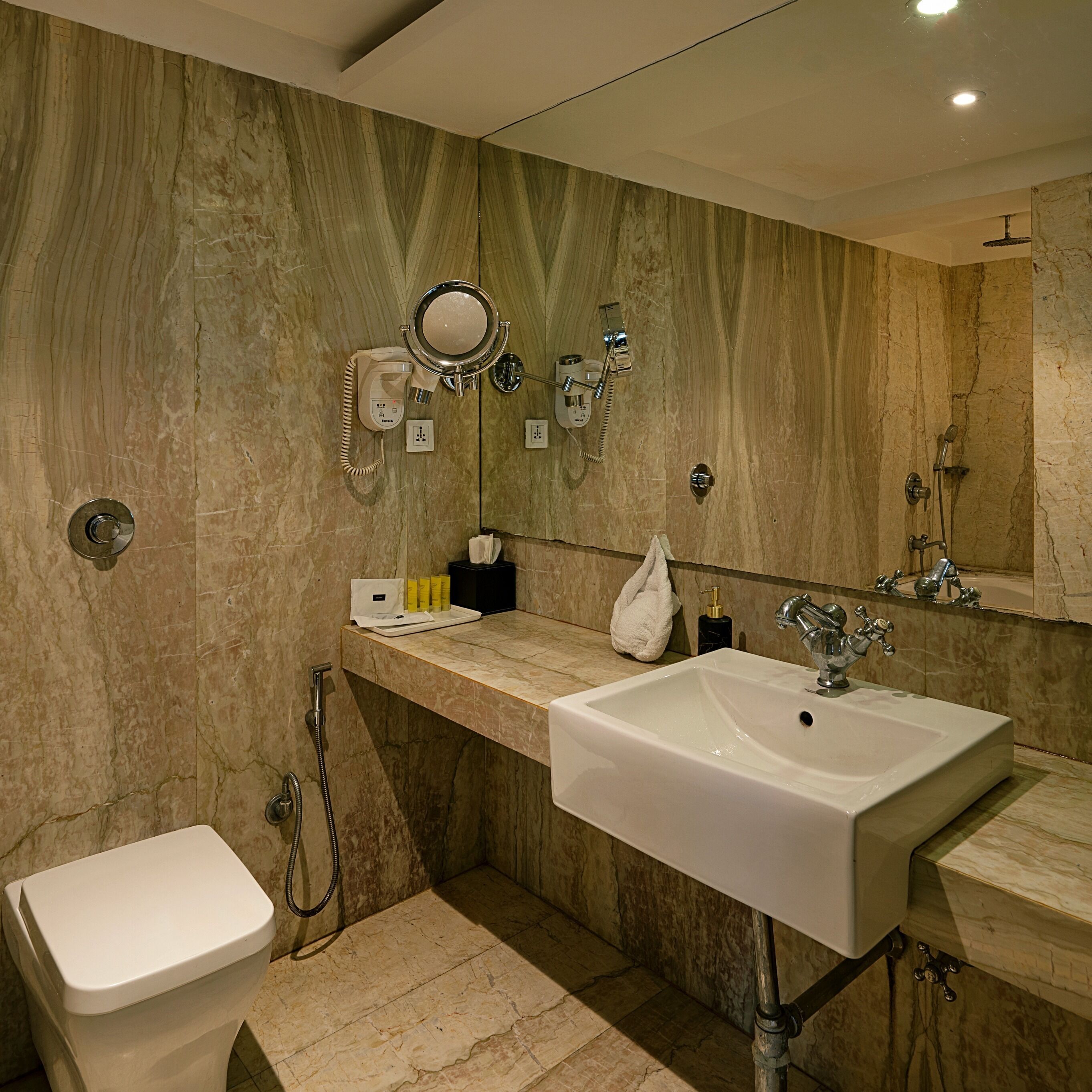 A modern bathroom with a large sink, a toilet, and a shower.
