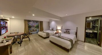Una habitación de hotel con cama, escritorio, silla, televisor y un cuadro en la pared.