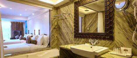 A modern bathroom with a marble sink, a large mirror, and a shower area.