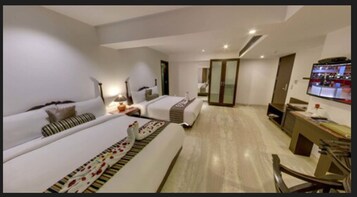 A hotel room with two beds, a desk, a TV, and a wardrobe.