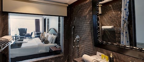 Un baño moderno con un espejo grande, una bañera y un lavamanos.