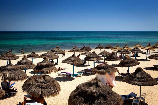 Privat strand, parasoller og sandvolleyball