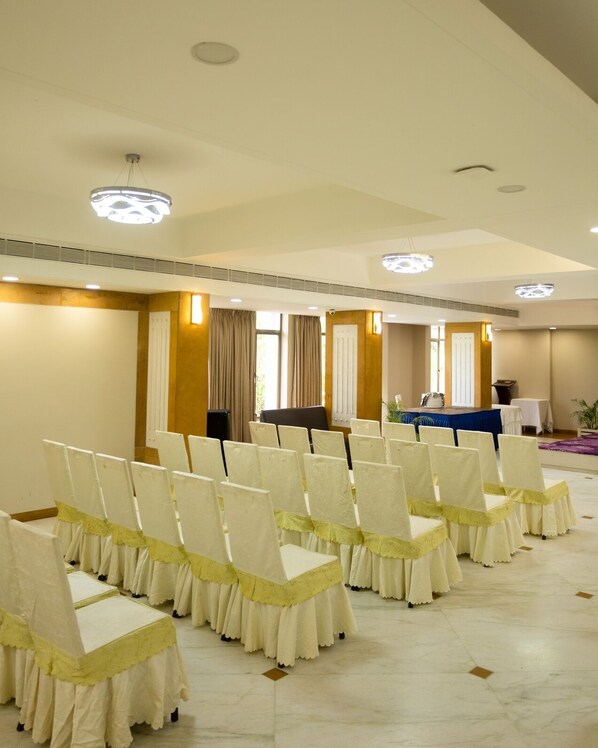 A conference room with rows of chairs, a podium, and a table with a blue tablecloth.