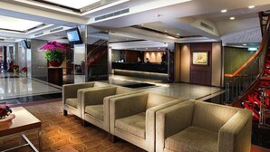 A modern lobby with a reception desk, seating area, and a staircase. - Gala Hotel (Taipei)