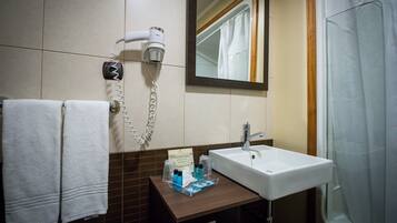 A bathroom with a white sink, a hairdryer, and a mirror.