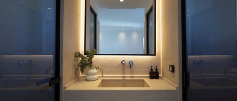 A bathroom with a mirror, sink, and two bottles of soap.