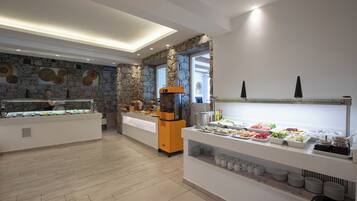 Een buffetgedeelte met diverse gerechten, een stenen muur en een modern keukenapparaat.