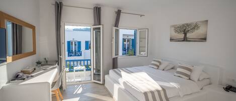 Un dormitorio moderno con una cama grande, un escritorio y vistas al exterior.