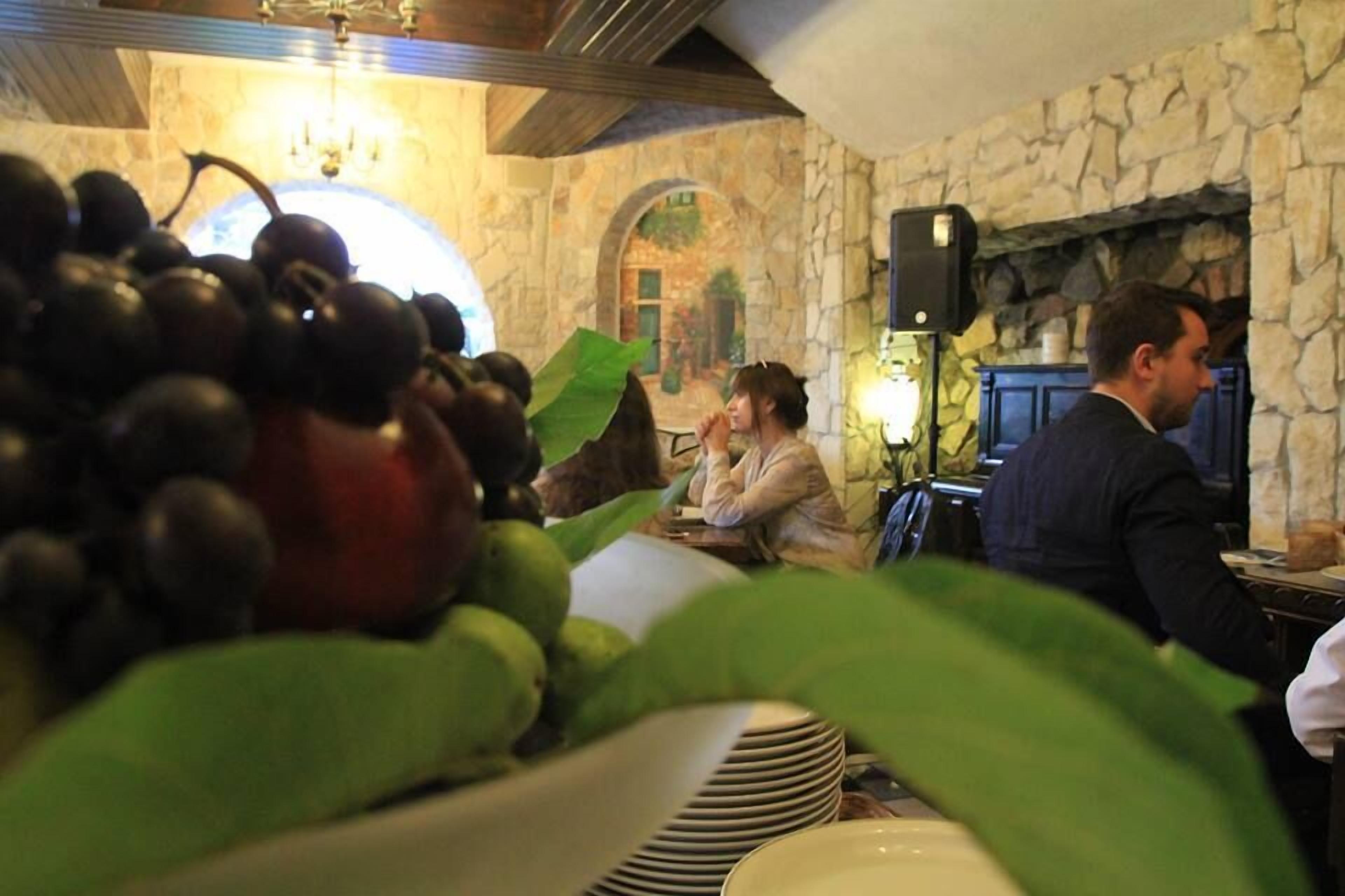 Un restaurante con paredes de piedra, una chimenea y una mesa con un cuenco de fruta.