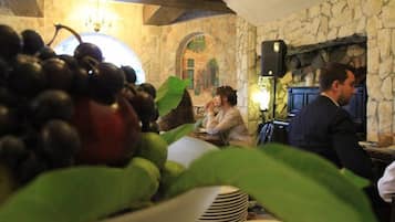 Un restaurante con paredes de piedra, una chimenea y una mesa con un cuenco de fruta.