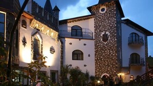 A castle-like building with a tower, stone walls, and arched windows. - Hunter Prince Castle Hotel  (Turda)