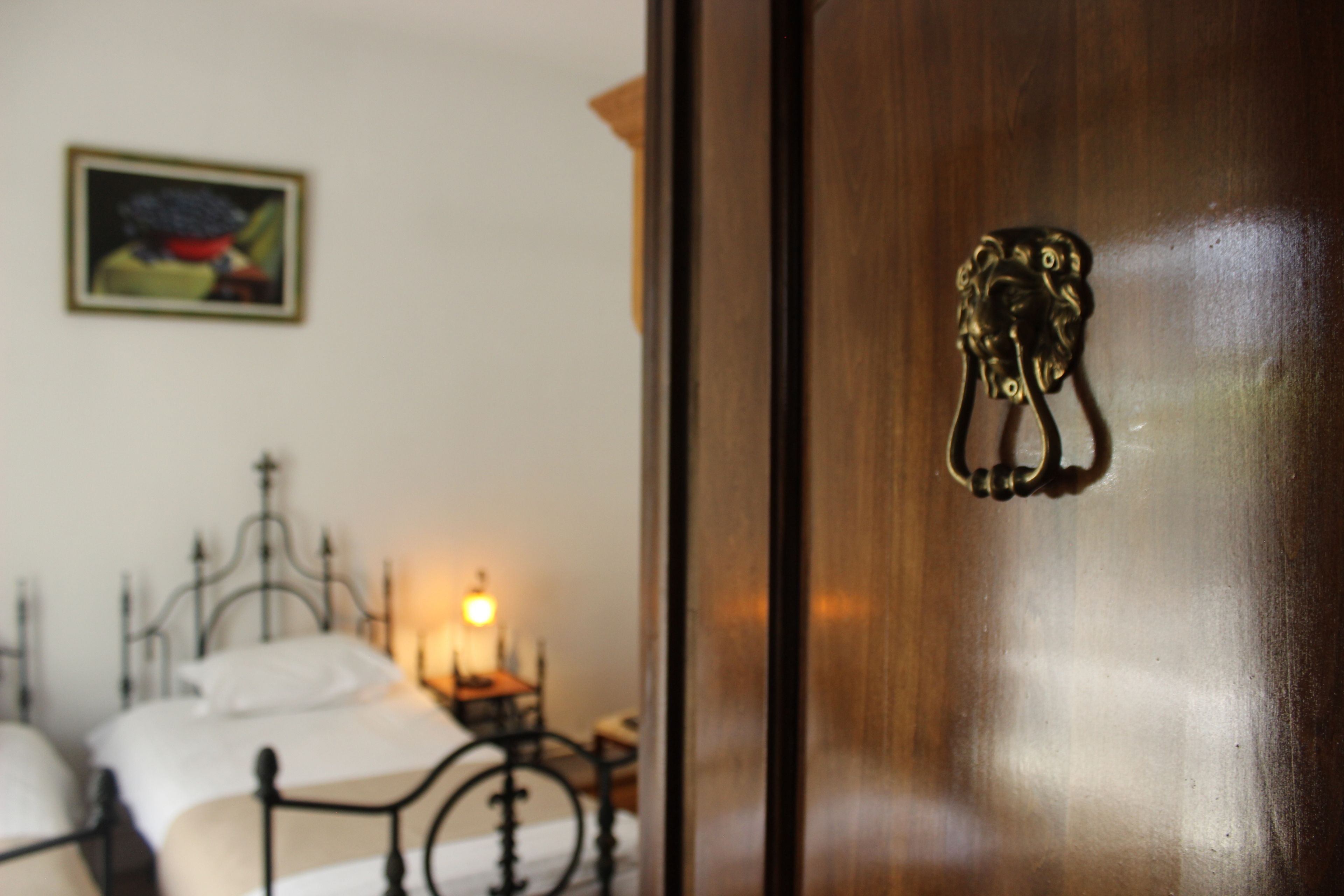 A wooden door with a brass handle and a framed picture on the wall.