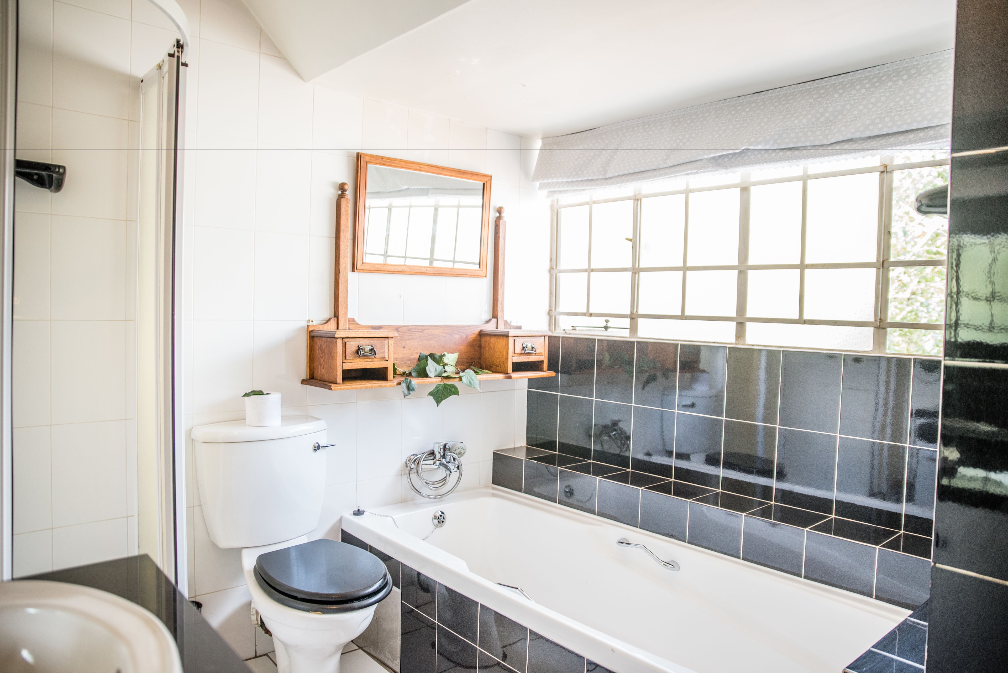 Une salle de bain avec des toilettes, une baignoire et une fenêtre donnant sur un beau paysage.