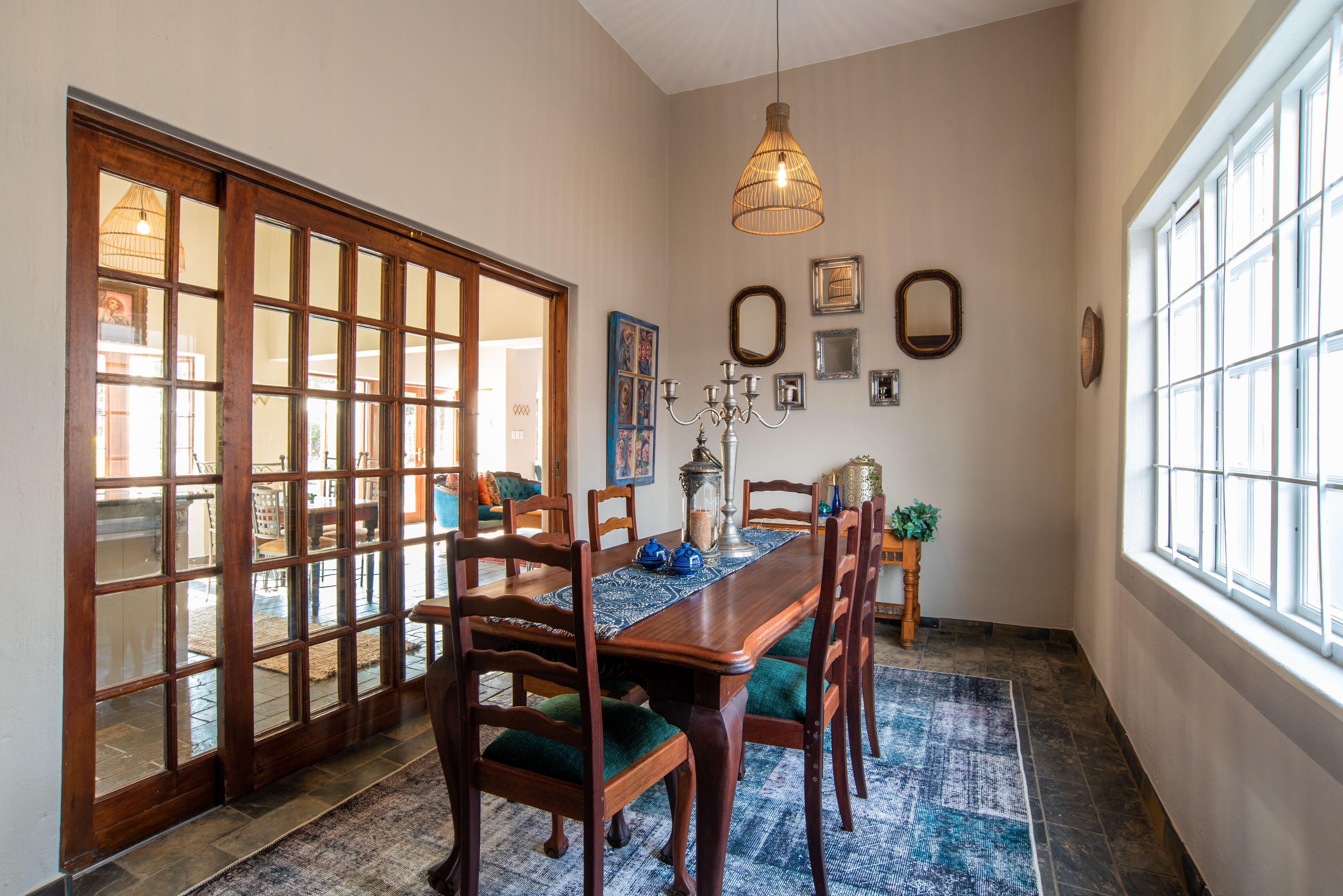 A dining area with a wooden table, chairs, and a patterned rug.