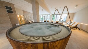 A hot tub with wooden panels, a lounge area with chairs, and a view of the outdoors. - Hotel Termal - Sava Hotels & Resorts (Moravske Toplice)